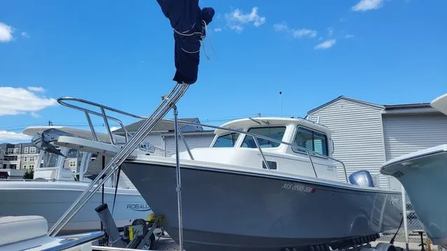 Slide: The Image of A 2020 Parker 2320 SC boat is on a trailer under a blue sky. - 2
