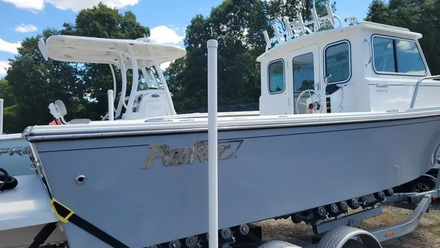 Slide: The Image of A 2020 Parker 2320 SC boat on a trailer, surrounded by trees. - 3