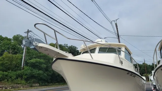 The Image of A 2007 Parker 2520XL boat is on a trailer beside a road. - 1