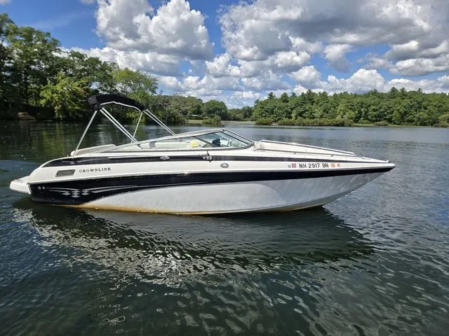 Slide: The Image of A 2003 Crownline 230 BR boat floats on a calm lake under a cloudy sky. - 27