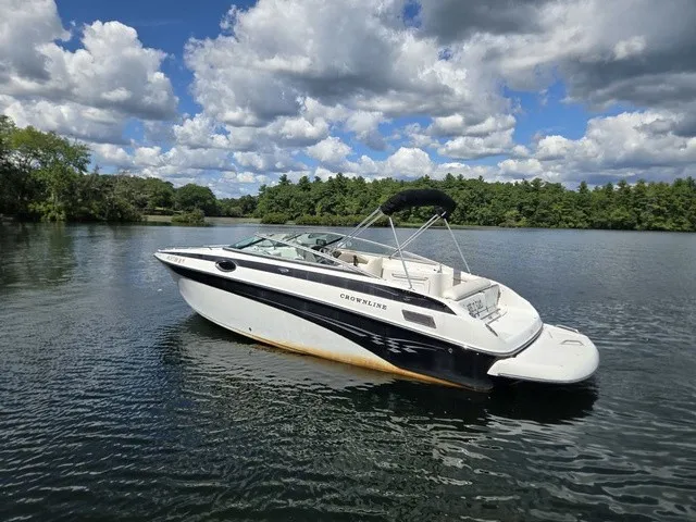 Slide: The Image of A 2003 Crownline 230 BR boat floats on a calm lake under a cloudy sky. - 25
