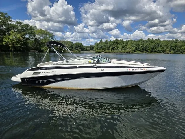 The Image of A 2003 Crownline 230 BR boat floats on a calm lake under a cloudy sky. - 1