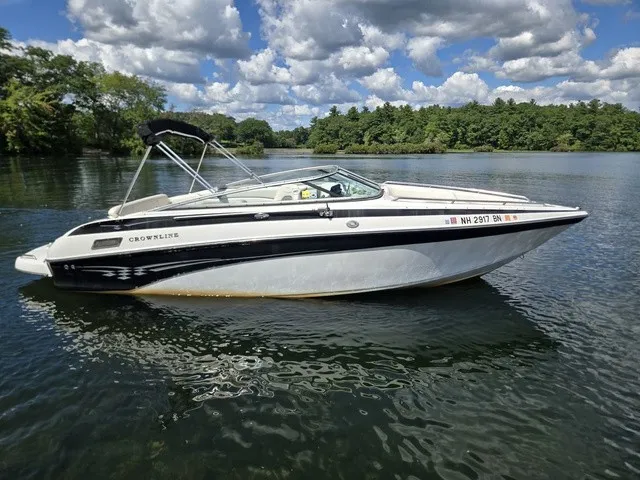 Slide: The Image of A 2003 Crownline 230 BR boat floats on a calm lake under a cloudy sky. - 24