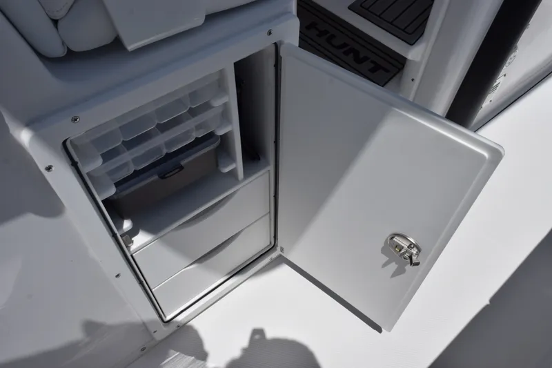 Slide: The Image of Open storage compartment on a 2027 Sea Hunt Gamefish 30FS boat, featuring organized shelves and drawers. - 20
