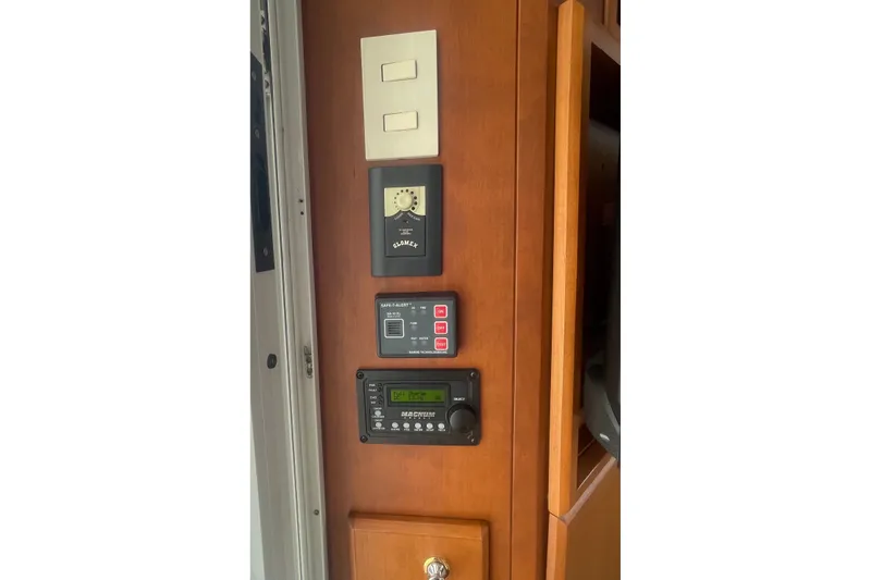 Slide: The Image of Control panel inside 2006 Silverton 34 Convertible boat, featuring switches and electronic displays. - 46