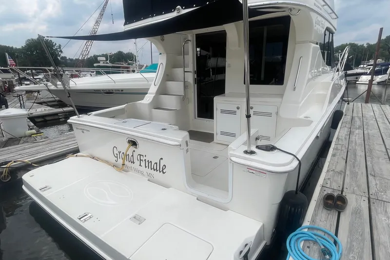 Slide: The Image of 2006 Silverton 34 Convertible yacht docked, featuring spacious deck and sleek design. - 20