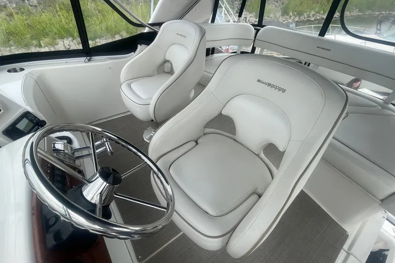 Slide: The Image of Interior of 2006 Silverton 34 Convertible yacht with white captain's chairs and steering wheel. - 32