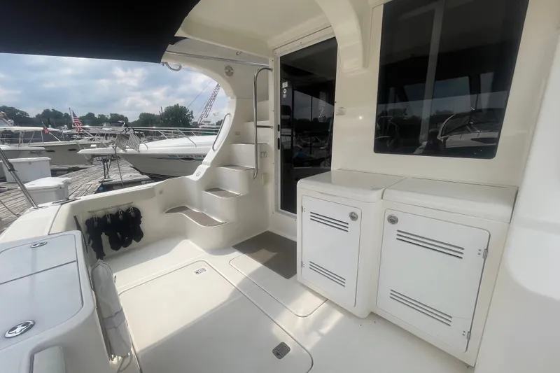 Slide: The Image of 2006 Silverton 34 Convertible yacht interior with steps, storage, and docked boats in background. - 21