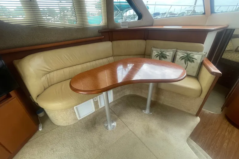 Slide: The Image of Interior of 2006 Silverton 34 Convertible yacht with beige seating and wooden table. - 45