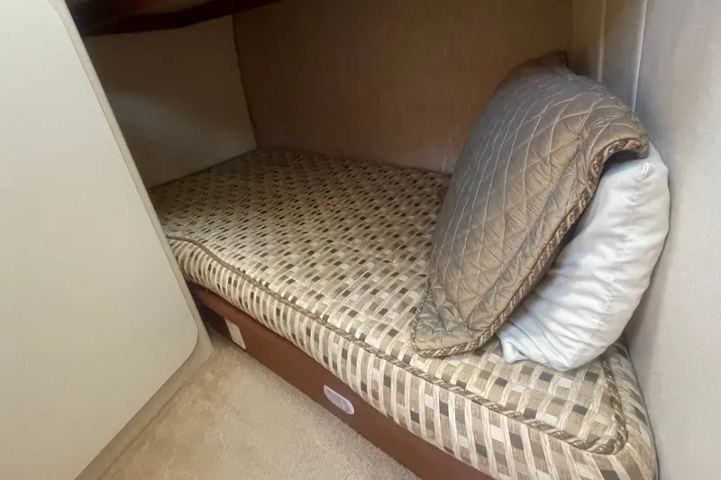 Slide: The Image of 2006 Silverton 34 Convertible cabin with patterned bedding and pillows. - 55