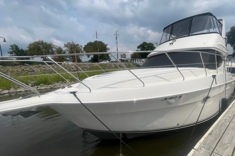 Slide: The Image of 2006 Silverton 34 Convertible yacht docked by a scenic shoreline. - 13