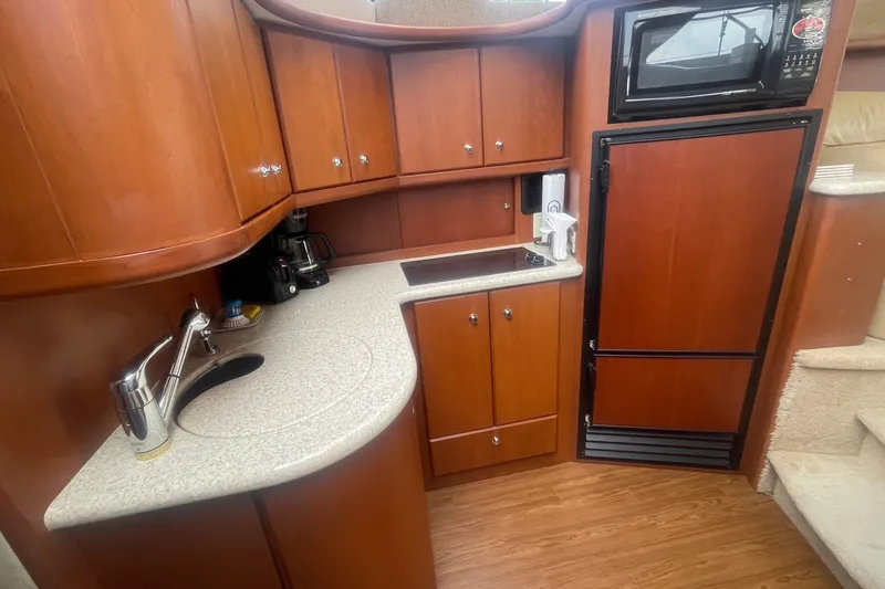 Slide: The Image of 2006 Silverton 34 Convertible yacht kitchen with wood cabinets, sink, and appliances. - 48