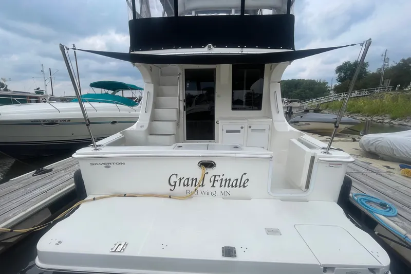 Slide: The Image of 2006 Silverton 34 Convertible boat docked, featuring "Grand Finale" name on the stern. - 12