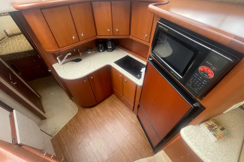 Slide: The Image of Interior of 2006 Silverton 34 Convertible yacht kitchen with wood cabinets and modern appliances. - 47