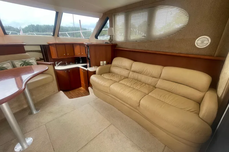 Slide: The Image of Luxurious interior of 2006 Silverton 34 Convertible yacht with beige sofa and kitchenette. - 40