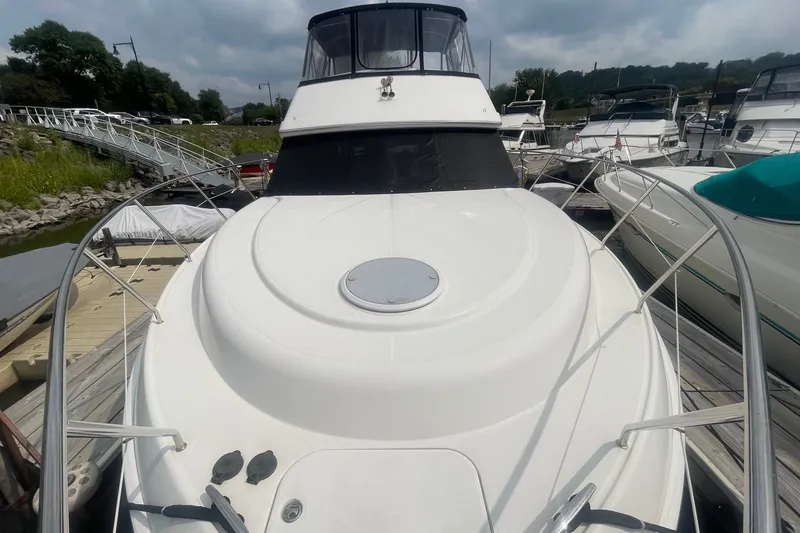 Slide: The Image of 2006 Silverton 34 Convertible yacht docked at marina, showcasing sleek design and spacious deck. - 16