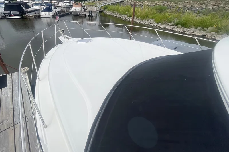 Slide: The Image of 2006 Silverton 34 Convertible yacht docked at a marina, showcasing sleek design and spacious deck. - 14
