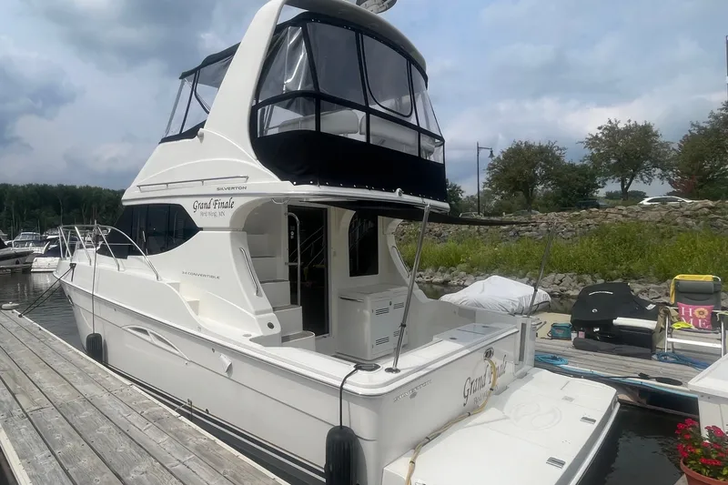 Slide: The Image of 2006 Silverton 34 Convertible yacht docked at marina, featuring sleek design and spacious deck. - 9