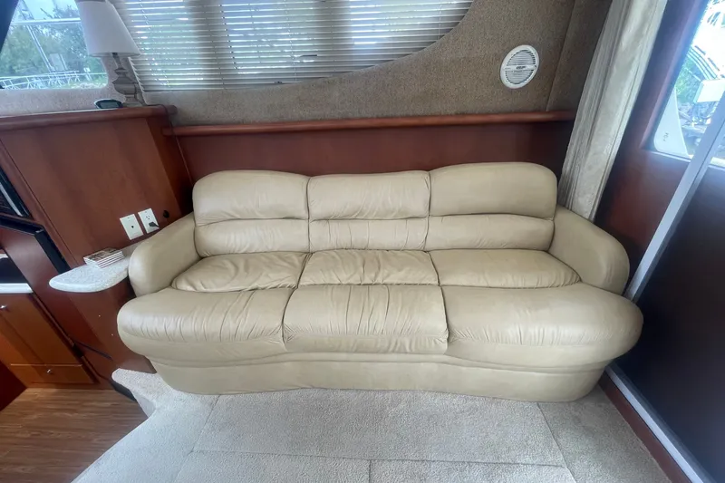 Slide: The Image of Beige leather sofa inside 2006 Silverton 34 Convertible yacht, with wooden interior accents. - 44
