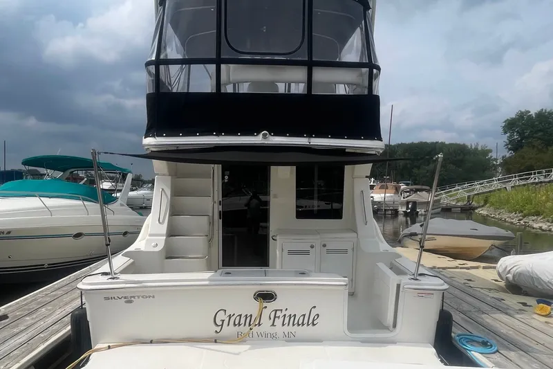 Slide: The Image of 2006 Silverton 34 Convertible yacht docked, rear view with "Grand Finale" name. - 11