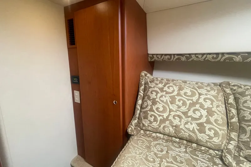 Slide: The Image of Interior of 2006 Silverton 34 Convertible with patterned bedding and wooden cabinetry. - 58