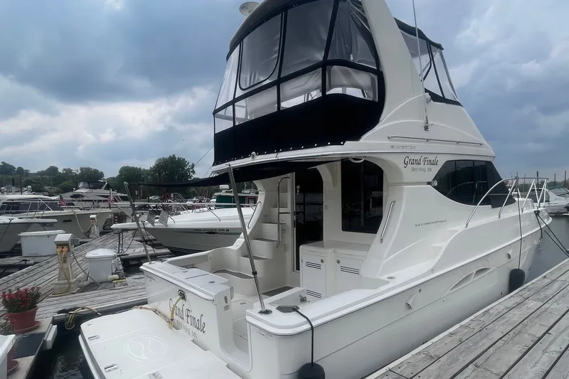 Slide: The Image of 2006 Silverton 34 Convertible yacht docked at marina under cloudy sky. - 10