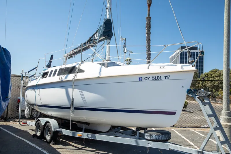 The Image of 2004 Hunter 260 sailboat on trailer in sunny marina setting. - 0