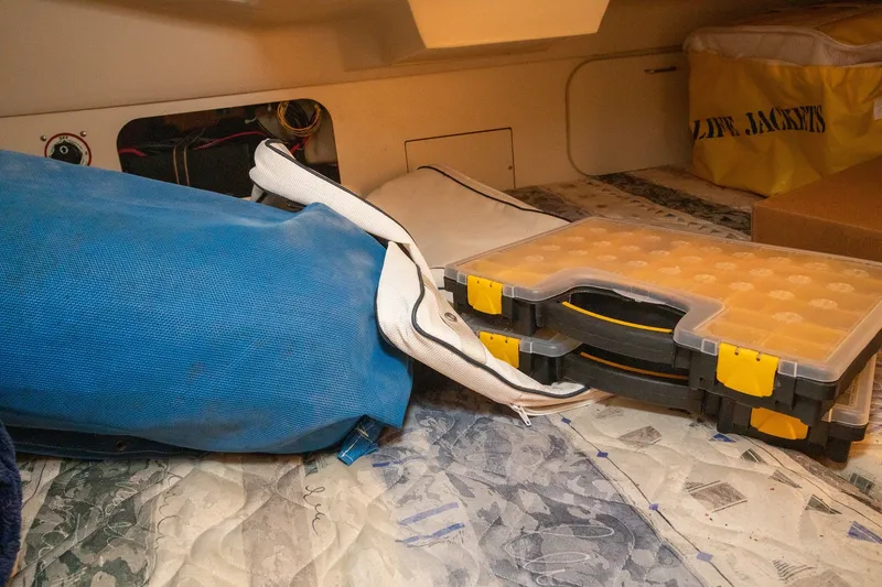 Slide: The Image of Interior of a 2004 Hunter 260 sailboat with storage items and life jackets. - 14