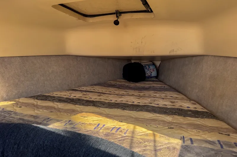 Slide: The Image of Interior cabin view of a 2004 Hunter 260 sailboat with a cozy sleeping area. - 15