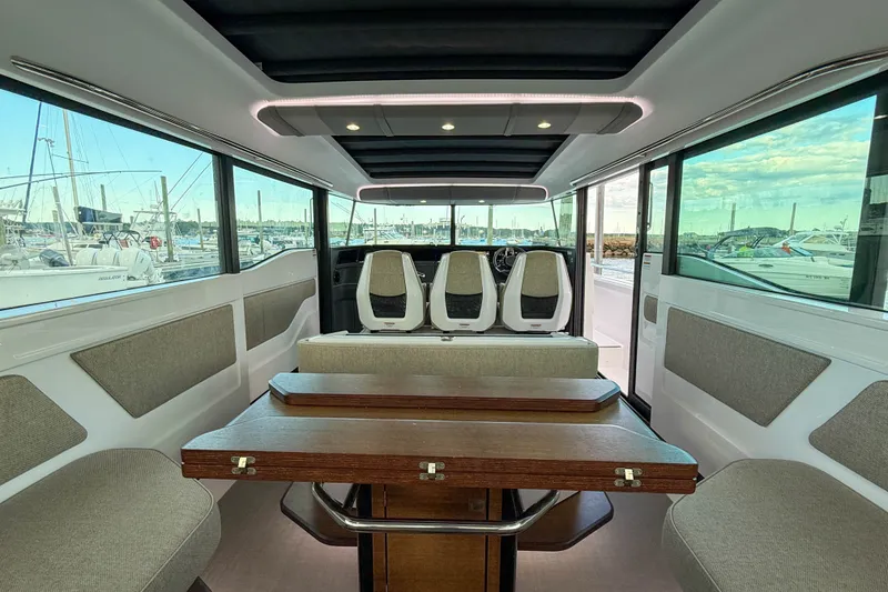 Slide: The Image of Interior of 2023 Axopar 45 XC Cross Cabin, featuring seating and a wooden table. - 19