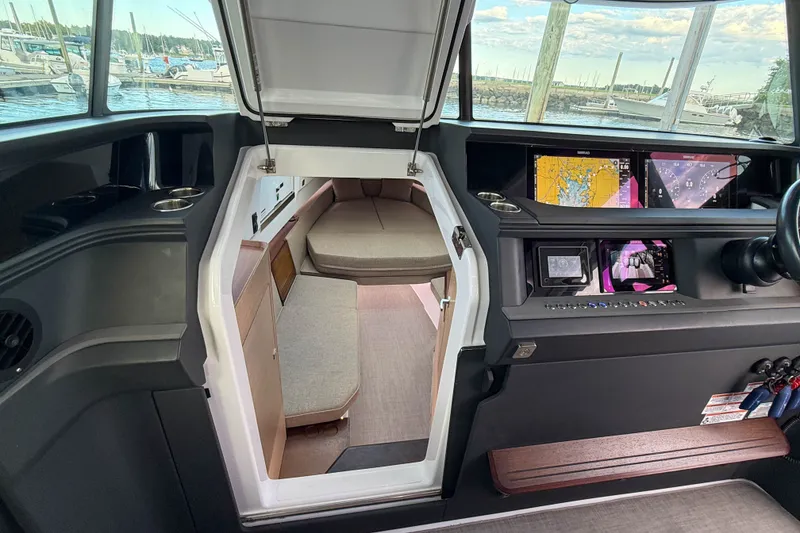 Slide: The Image of 2023 Axopar 45 XC Cross Cabin interior with navigation displays and cozy seating area. - 27