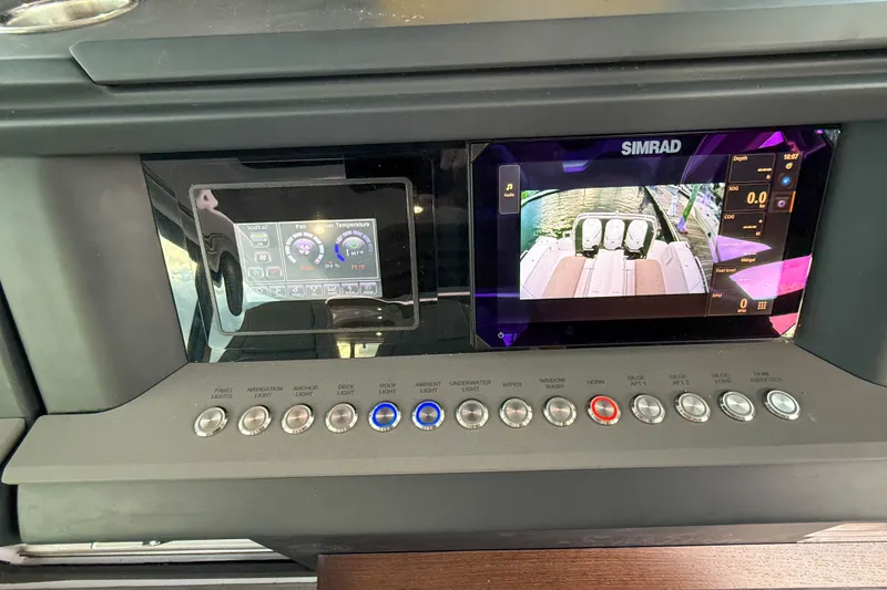 Slide: The Image of Control panel of 2023 Axopar 45 XC Cross Cabin with Simrad display and various switches. - 25