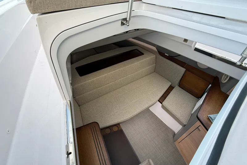Slide: The Image of Interior cabin of 2023 Axopar 45 XC Cross Cabin, featuring modern seating and wood accents. - 33