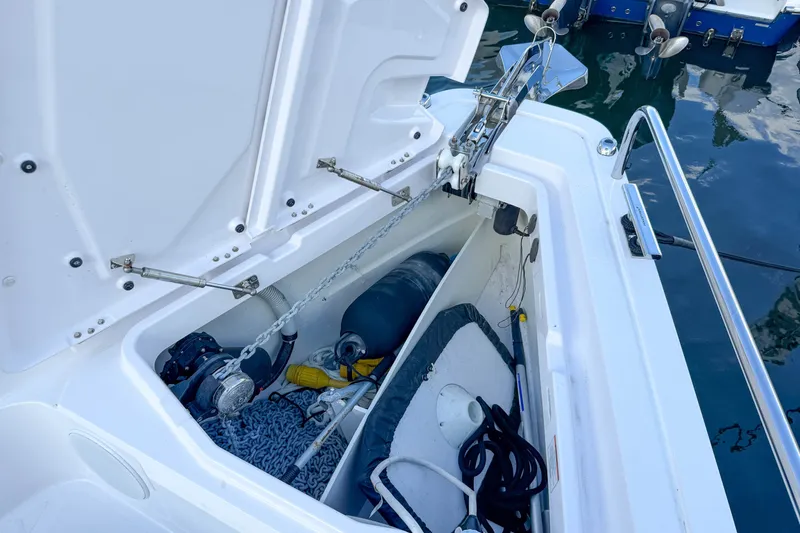 Slide: The Image of Anchor storage compartment on 2023 Axopar 45 XC Cross Cabin boat, featuring chain and equipment. - 14
