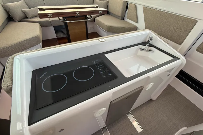 Slide: The Image of 2023 Axopar 45 XC Cross Cabin interior with modern kitchenette and seating area. - 17