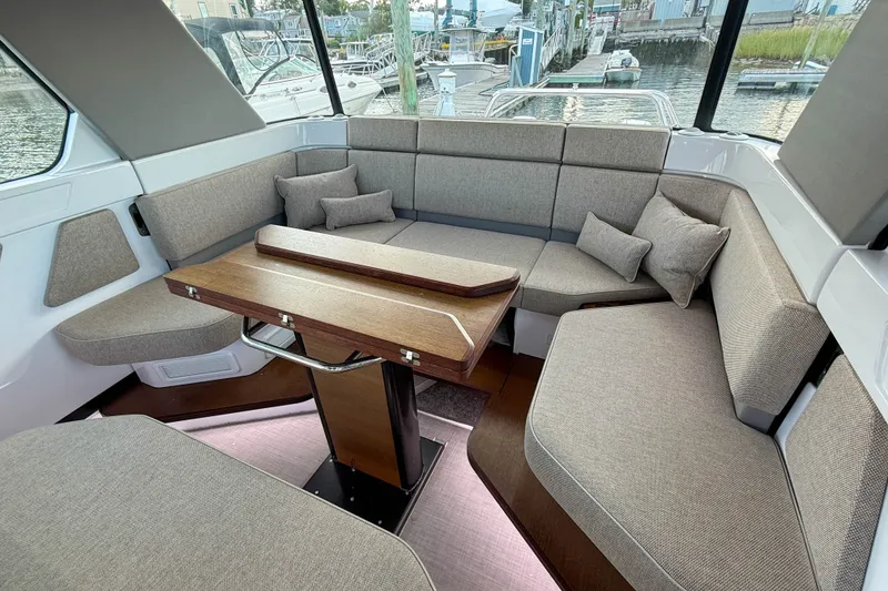 Slide: The Image of Interior of 2023 Axopar 45 XC Cross Cabin with plush seating and wooden table. - 18