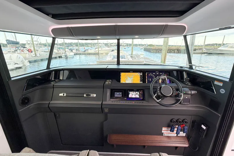 Slide: The Image of 2023 Axopar 45 XC Cross Cabin helm with advanced navigation displays and steering wheel. - 26