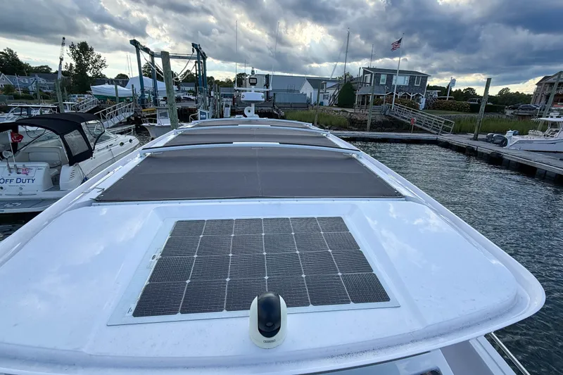 Slide: The Image of 2023 Axopar 45 XC Cross Cabin with solar panel docked at marina under cloudy sky. - 13