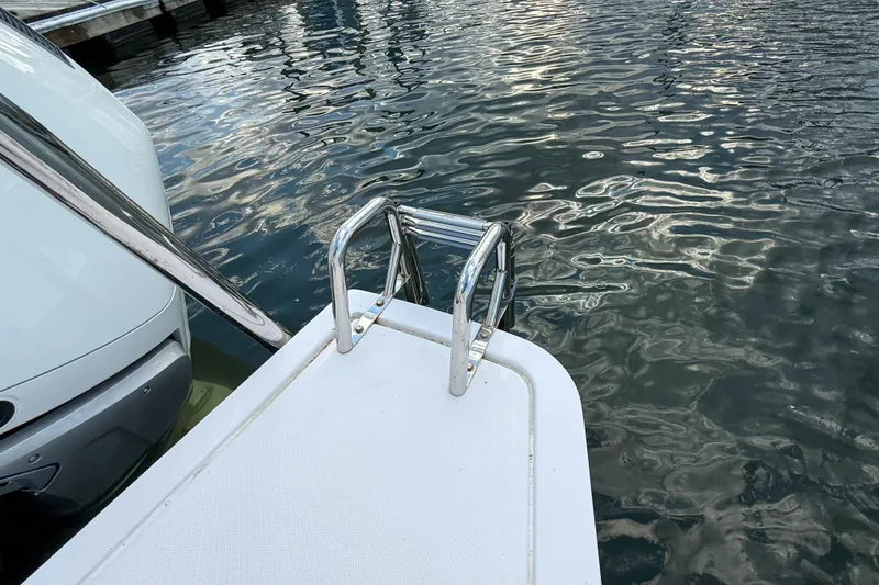 Slide: The Image of 2023 Axopar 45 XC Cross Cabin swim platform with ladder by the water. - 37