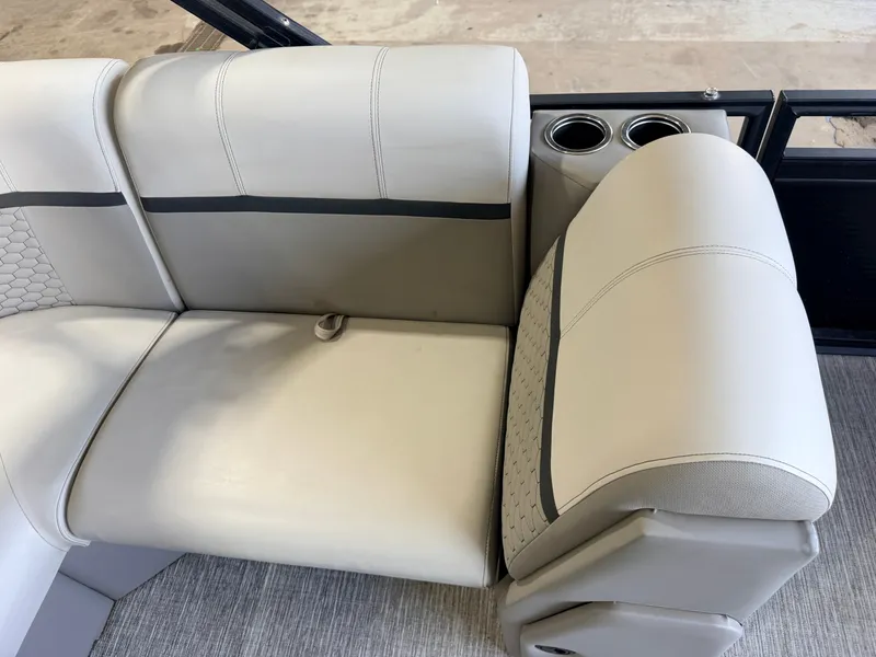 Slide: The Image of The image shows a light-colored, cushioned bench seat with cup holders on a boat. - 35
