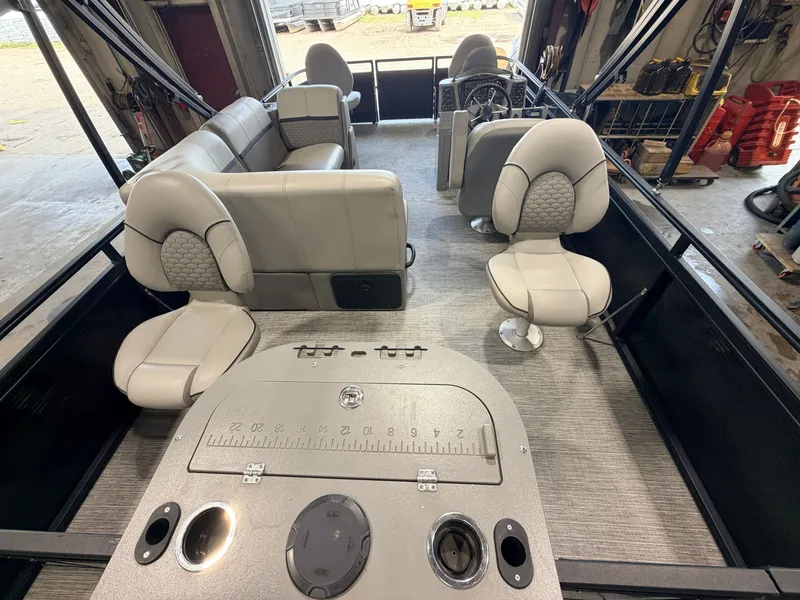 Slide: The Image of The image shows the interior of a 2023 Apex Marine Qwest L818 Fish with a 60HP Honda 4-Stroke engine. There are several cushioned seats and a helm with instruments. - 7
