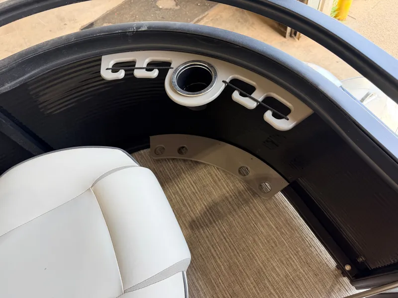 Slide: The Image of A sleek seating area with white upholstery and a cup holder on a boat. - 13