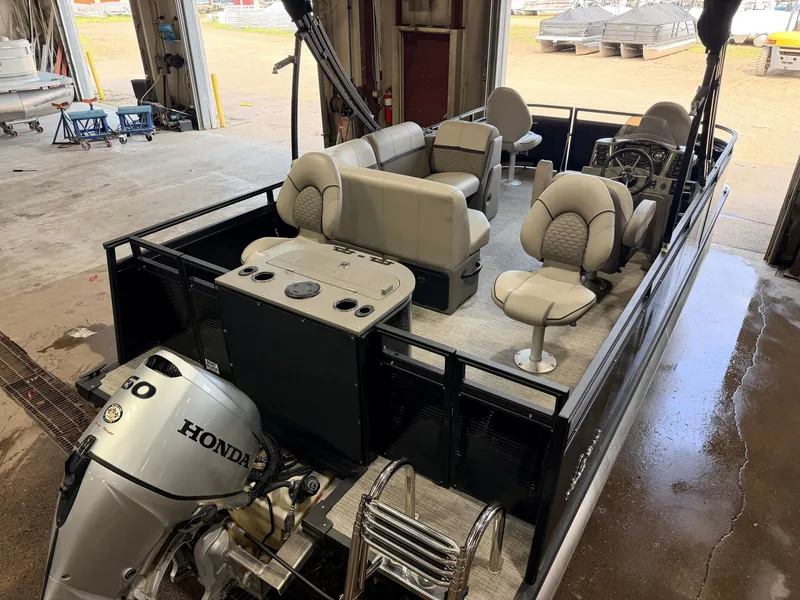 Slide: The Image of A modern pontoon boat with gray seating and a Honda 60HP outboard motor in a workshop. - 6
