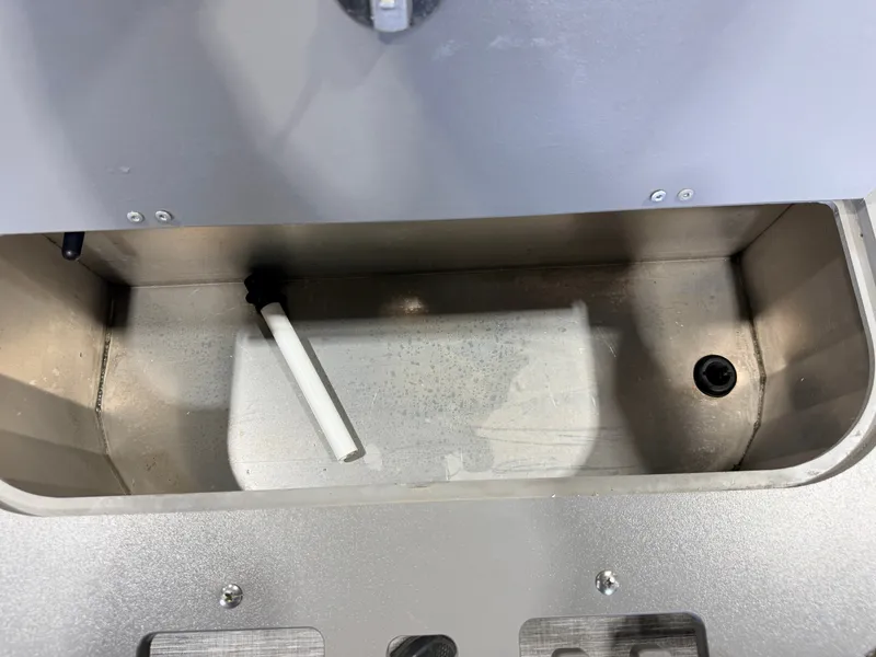 Slide: The Image of An empty rectangular metal compartment with a white pipe and a drain hole. - 48