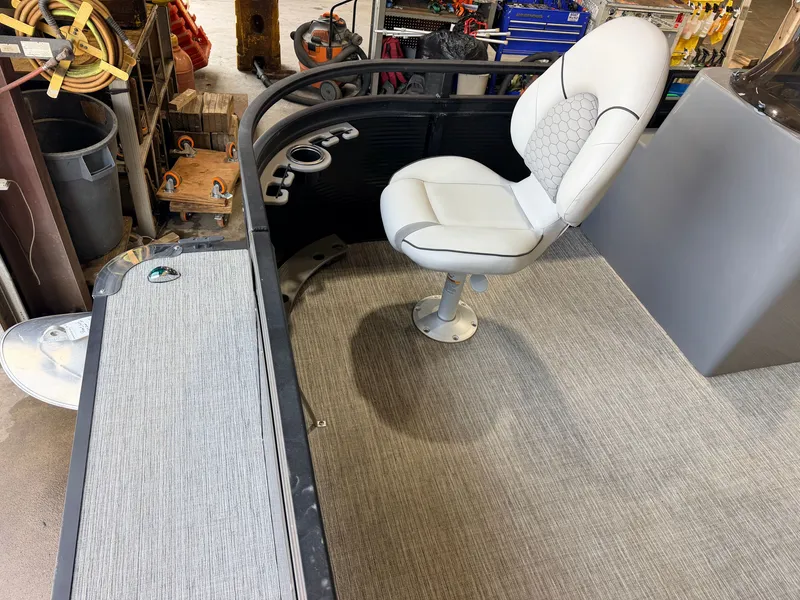 Slide: The Image of A modern boat seat on gray carpet, surrounded by fishing rod holders and equipment. - 15