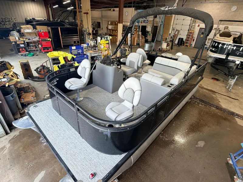 The Image of A modern pontoon boat with gray seats and black railing in a workshop setting. - 1