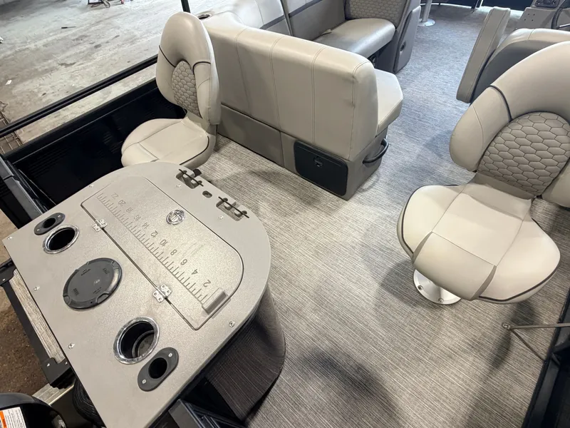 Slide: The Image of Interior of a modern pontoon boat with beige seating and a table featuring cup holders. - 40