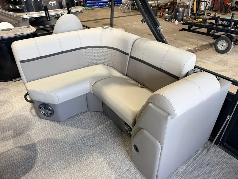Slide: The Image of A modern gray seating sofa in a boat with speakers and padded backrests. - 32