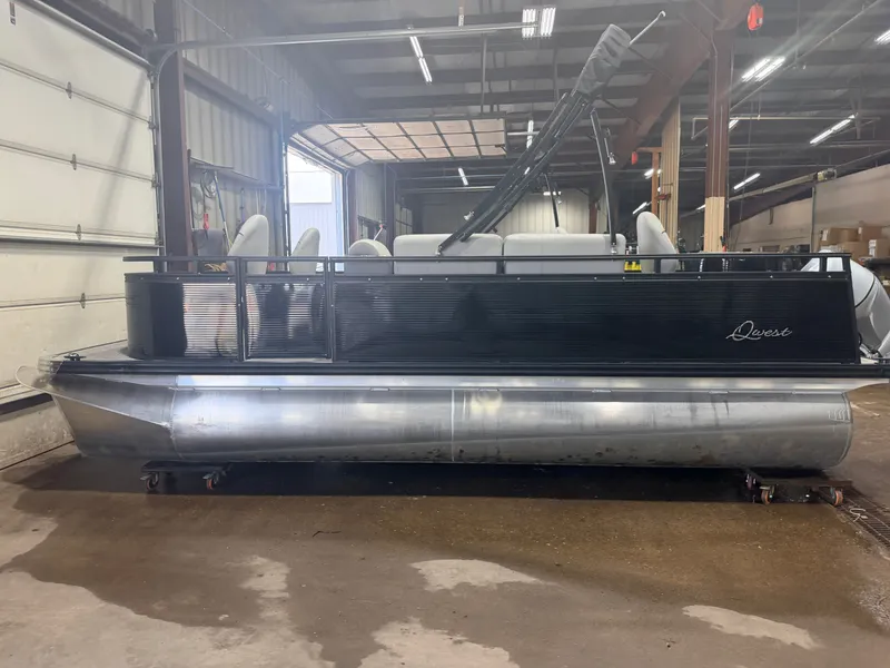 Slide: The Image of A 2023 Apex Marine Qwest L818 pontoon boat with black railing and silver hull in a warehouse. - 31