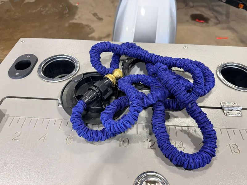 Slide: The Image of A blue coiled rope lies on a gray surface with a measuring scale and round openings. - 49
